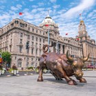 La statua del Toro di Bronzo sul Bund di Shanghai simboleggia forza e prosperità, icona moderna ispirata al celebre toro di Wall Street.