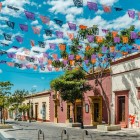 Fotografia di strada che cattura le vivaci architetture coloniali di Oaxaca, arricchite dalle colorate decorazioni del Día de los Muertos che animano il centro storico con tradizione e magia.