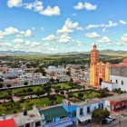 Panoramica della Cattedrale di Tamazulapam a Oaxaca, immersa nel cuore della città e circondata da giardini verdi, edifici colorati e un paesaggio pittoresco che ne esalta la bellezza.