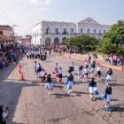 Piazza centrale di Tehuantepec , con il grande Municipio bianco affacciato sulla strada in pietra e portici coloniali a sinistra. Alberi rigogliosi completano l’atmosfera tranquilla.