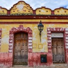 Un tipico negozio di scarpe in stile coloniale a San Cristóbal, con facciata giallo ocra e dettagli rossi scoloriti dal tempo, che raccontano il fascino autentico della città del Chiapas.