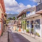Strada coloniale di San Cristóbal, con case colorate, balconi fioriti e tetti in terracotta, immersa tra le montagne del Chiapas. Un angolo autentico e ricco di fascino.