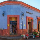 Venditori ambulanti maya davanti alla facciata colorata di un negozio coloniale nella città di San Cristóbal in Messico.
