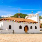 La Chiesa di San Lorenzo a Zinacantán, nel Chiapas, affascina con la sua facciata bianca e i dettagli colorati, centro spirituale della comunità tzotzil e luogo simbolo delle tradizioni indigene.