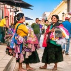 Due donne ambulanti tzotziles percorrono le strade di San Cristóbal de Las Casas con indumenti e biancheria ricamata, offrendo artigianato locale e custodendo vive le tradizioni indigene.