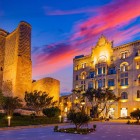 a Città Vecchia di Baku al tramonto incanta con mura medievali illuminate, palazzi eleganti, e la torre della vergine tra storia antica e fascino moderno nel cuore di Icherisheher.