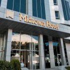 Esterni moderni del Midtown Hotel di Baku con facciata in vetro, pannelli chiari e ingresso luminoso. L’insegna dorata dona eleganza e uno stile contemporaneo raffinato.