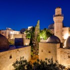 La vista posteriore del Palazzo degli Shirvanshah a Baku rivela eleganti cupole, minareti e architetture storiche illuminate, simbolo del ricco patrimonio culturale dell’Azerbaigian.