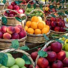 Ceste di frutta fresca e colorata al mercato Yasil Bazar di Baku mostrano prodotti locali e tradizioni gastronomiche dell’Azerbaigian in un’atmosfera vivace.