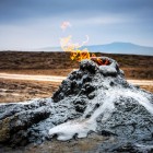 Vulcano di fango nel Parco Nazionale del Gobustan, in Azerbaigian, con emissioni di gas naturale che alimentano piccole fiamme in un paesaggio suggestivo e unico.