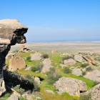 Paesaggio semi-desertico della penisola di Absheron in Azerbaigian, tra rocce, praterie e vista sul Mar Caspio, area storica ricca di testimonianze antiche.