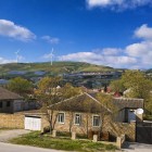 Il villaggio di Mereze, in Azerbaigian, mostra case in pietra con tetti inclinati e cortili recintati, immerse tra colline verdi: tipica architettura rurale del Caucaso.