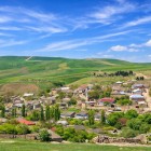 Il villaggio di Mereze, in Azerbaigian, si adagia tra dolci colline verdi, case in pietra e tetti colorati, immerso in un paesaggio rurale luminoso e autentico.