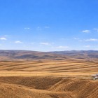 Colline ondulate e campi dorati si estendono all’orizzonte sotto un cielo limpido: è il paesaggio circostante del Mausoleo di Diri Baba, simbolo della quiete rurale dell’Azerbaigian.