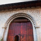 Il portale in legno del Caravanserraglio di Sheki, con arco in pietra decorato, riflette l’architettura della Via della Seta tra eleganza e funzionalità.