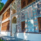 Il Palazzo del Khan di Sheki mostra ornamenti azeri con mosaici policromi, motivi floreali e geometrici, vetrate shebeke e decorazioni tipiche dell’arte caucasica.