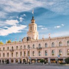 Il Municipio di Tbilisi sfoggia eleganti linee neoclassiche, facciata simmetrica in toni pastello e una torre con orologio che domina la piazza.