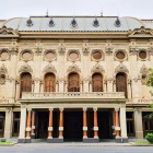 Il Teatro Rustaveli sfoggia una facciata neoclassica ricca di stucchi, archi eleganti e colonne imponenti, simbolo culturale e architettonico di Tbilisi.