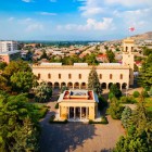 Vista aerea del Museo di Stalin a Gori, città natale del leader sovietico, con l’imponente edificio monumentale circondato da giardini e dal panorama urbano della Georgia centrale.