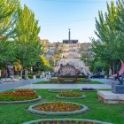 Il complesso della Cascade di Yerevan con giardini fioriti, sculture moderne e ampie scalinate monumentali che conducono al memoriale, tra viali alberati nel cuore della capitale armena.