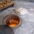 Preparazione del tradizionale lavash armeno cotto nel forno tonir: antica tecnica culinaria tra le esperienze autentiche più iconiche della cultura gastronomica armena.