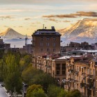 Panoramic view of Yerevan with Mount Ararat in the background. At sunrise, the city glows in warm sepia tones, creating a charming vintage effect.