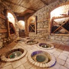 Cantina tradizionale armena con tipici recipienti sotterranei, dove il vino matura lentamente in ambienti freschi, tra pietra e mattoni, secondo antiche tecniche locali.