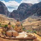 Monastero di Noravank nel canyon di Vayots Dzor, Armenia: complesso medievale in pietra rossa immerso tra montagne spettacolari, simbolo di storia e spiritualità.
