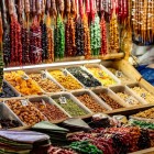 Tradizionale bancarella del mercato di Kutaisi con frutta secca e churchkhela colorate. Sapori autentici georgiani esaltati da calde luci e atmosfere vivaci.