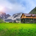 Tipica casa di montagna a Juta, ai piedi del Chaukhebi: immersa in verdi praterie e circondata da vette imponenti, offre un paesaggio autentico e suggestivo nel cuore del Caucaso.