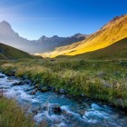 Torrente cristallino scorre tra prati alpini e dolci vallate, ai piedi del Monte Chaukhebi, regalando un paesaggio suggestivo nel cuore del Caucaso georgiano.