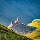 Rovine di un’antica fortezza nella Valle di Truso, arroccata su un colle panoramico tra i vasti paesaggi montani del Caucaso georgiano.