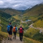 Escursionisti in trekking sul sentiero che scende verso Kvesheti, tra vallate aperte e montagne del Caucaso che accompagnano il cammino verso il fondovalle georgiano.