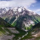 Vista sul Monte Dalakhora e sulla valle del fiume Mestiachala, tra pendii verdi e pareti rocciose. Un paesaggio ampio e naturale nel cuore della Svaneti.