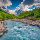 Le acque azzurre del fiume Adishchala scorrono lente ai piedi del monte Shkhara, regalando al mattino una luce limpida sull’Alta Svaneti e sul villaggio di Adishi.