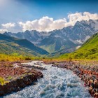 Un fiume di montagna scorre ai piedi del ghiacciaio Tetnuldi, tra le luci limpide dell’estate. Dal passo Chkhunderi si apre una vista ampia sull’Alta Svaneti, tra le vette del Caucaso.