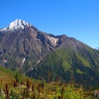 Sentiero tra prati d’alta quota a Lentekhi, con vista sulle montagne del Caucaso. Pendii verdi e creste rocciose accompagnano il percorso in un paesaggio ampio e aperto.