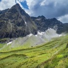Vista sul monte Dolomisitsveri nella catena del Grande Caucaso, nella regione di Racha-Lechkhumi. Creste rocciose e pendii verdi si alternano nel paesaggio.