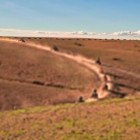 Pista sterrata nel deserto di Agafay, tra colline aride e ampi spazi aperti con le montagne dell’Atlante sullo sfondo.