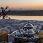 Tè alla menta servito al tramonto nel deserto di Agafay, tra silenzi, luci calde e una piscina affacciata sulle colline del Marocco.