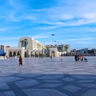 Nel cuore di Casablanca, la Piazza delle Nazioni Unite unisce storia e modernità tra archi eleganti, cielo terso e vita quotidiana vibrante.