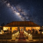 Nel deserto di Merzouga il cielo stellato e la Via Lattea illuminano il campo tendato, creando un’atmosfera intima e suggestiva nel Sahara.