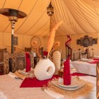 Ristorante elegante all’interno di un campo tendato luxury a Merzouga, tra arredi berberi, luci soffuse e atmosfera raffinata nel cuore del Sahara marocchino.