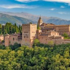 L'Alhambra domina Granada con le sue mura, torri e palazzi nazarí ai piedi della Sierra Nevada. Un capolavoro dell'arte islamica e simbolo senza tempo dell'Andalusia.