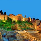 L'Alcazaba di Malaga domina il Teatro Romano con le sue mura illuminate. Un luogo dove l'eredità araba e quella romana si incontrano nel cuore dell'Andalusia.