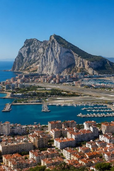 La Rocca di Gibilterra domina il panorama con le sue imponenti pareti calcaree, affacciandosi sul porto e sullo Stretto che unisce il Mediterraneo all'Oceano Atlantico.