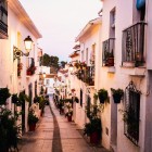 Una delle caratteristiche vie di Mijas si distingue per le case bianche, i balconi fioriti e la pavimentazione in pietra, offrendo scorci autentici sulla Costa del Sol.