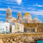 La Cattedrale di Santa Croce sul Mare domina il profilo di Cadice, affacciata sull’Atlantico tra mura storiche, case bianche e scorci luminosi del centro antico.