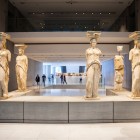 Le celebri Cariatidi accolgono i visitatori nel Nuovo Museo dell'Acropoli, custodi dell'antica Atene e simbolo dell'eleganza dell'arte classica greca.