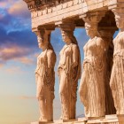 La Loggia delle Cariatidi impreziosisce il Tempio dell'Eretteo con sei eleganti figure femminili scolpite nella pietra. Al tramonto, questo capolavoro dell'Acropoli racconta tutta la raffinatezza dell'antica Grecia.